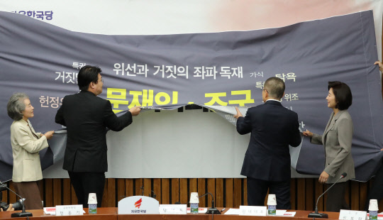 자유한국당 황교안 대표와 나경원 원내대표가 26일 국회에서 열린 '저스티스리그 출범식 및 1차 회의'에서 걸개막을 찢는 퍼포먼스를 하고 있다. 연합뉴스